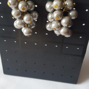 A dangling pair of earrings with bunches of grey beads